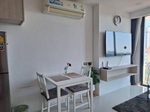 a kitchen with a white table and chairs and a tv at DOR ApartHotel in Chişinău