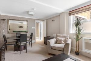 a living room with a table and chairs and a dining room at Beaufort House - Knightsbridge in London