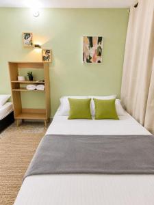 a bedroom with a bed with two green pillows at Absolute Nova Hotel in Medellín +16 photos