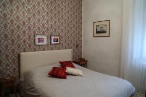 a bedroom with a bed with two red pillows on it at Casa di Sergio in Gambassi Terme