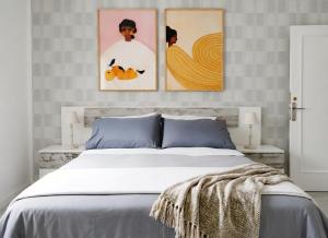 a bedroom with three paintings on the wall at Muy acogedor, a 5 min a pie del centro, Cama 1'60, Wifi y Netflix in San Vicente de la Barquera