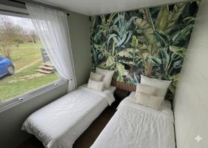 twee eenpersoonsbedden in een kamer met een raam bij Base de loisirs du Colvert in Bonzée-en-Woëvre