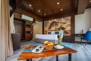 a bedroom with a bed and a table with a bowl of fruit at Pearl Continental Attabad Lake, Hunza in Hunza Valley