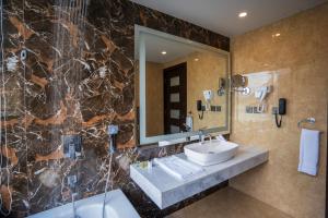 a bathroom with a sink and a mirror at Pearl Continental Attabad Lake, Hunza in Hunza Valley +36 photos