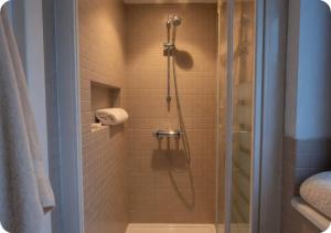 a bathroom with a shower with a glass door at Chalet Broski - Spacious Chalet with Hot Tub, Sauna & BBQ in Planvillard +38 photos