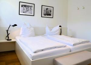 two white beds in a room with two pictures on the wall at Insel Landhaus Seaside in Gager