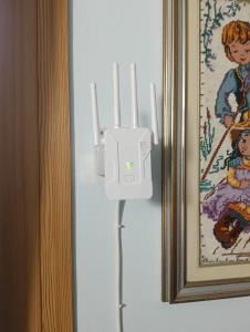 a white charger on a wall next to a picture at Casa Beatrice in Spilimbergo