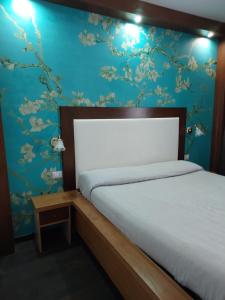 a bedroom with a bed with a blue wall at B&B Radici24 in Battipaglia