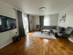 a living room with a couch and a tv at Villa Lindäng Apartment -Vimmerby in Vimmerby