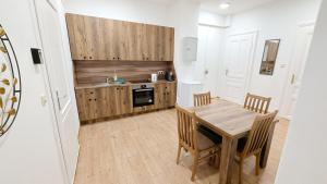 eine Küche mit einem Holztisch und Stühlen in einem Zimmer in der Unterkunft Lovely Apartment - 15 Min from Airport & City Center EZ 9 6 in Wien