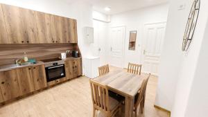 eine Küche mit einem Holztisch und einem Esszimmer in der Unterkunft Lovely Apartment - 15 Min from Airport & City Center EZ 9 6 in Wien + 2 Fotos