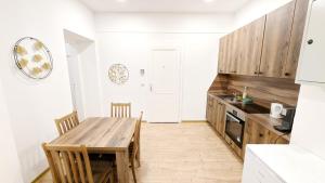 eine Küche mit einem Holztisch und einem Esszimmer in der Unterkunft Lovely Apartment - 15 Min from Airport & City Center EZ 9 6 in Wien
