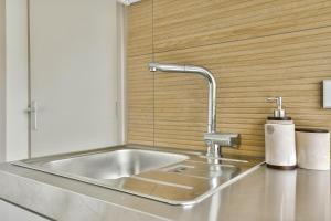a stainless steel kitchen sink with a faucet at The Rietvink Residence in Wervershoof