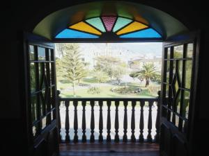 a window with a view of a garden from a porch at Casona del Inca Cajamarca in Cajamarca