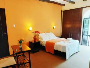 a bedroom with a bed and a table with flowers on it at Casona del Inca Cajamarca in Cajamarca