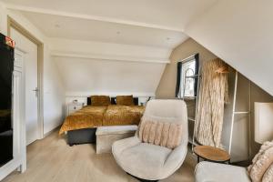 a bedroom with a bed and a chair at The Rietvink Residence in Wervershoof