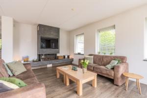 a living room with two couches and a coffee table at Hoogelandt 106F in De Koog