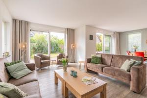 a living room with two couches and a coffee table at Hoogelandt 106F in De Koog