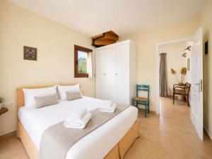 a bedroom with a large white bed with two towels at Villa Aphrodite in Plaka +11 photos