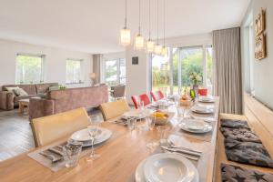 a dining room and living room with a table and chairs at Hoogelandt 106F in De Koog