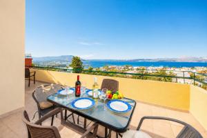 a table on a balcony with a view of the ocean at Villa Aphrodite in Plaka