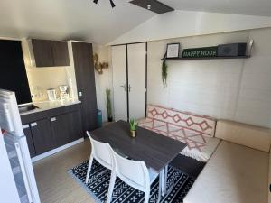 een eetkamer met een tafel en twee witte stoelen bij Base de loisirs du Colvert in Bonzée-en-Woëvre