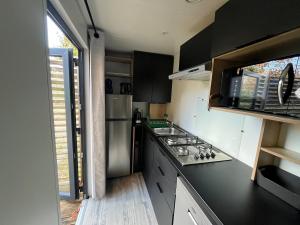 a small kitchen with a stove and a sink at La Cabane du Lac - Biscarrosse 5 étoiles in Biscarrosse