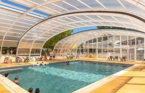 a rendering of a swimming pool with people in it at La Cabane du Lac - Biscarrosse 5 étoiles in Biscarrosse +12 photos