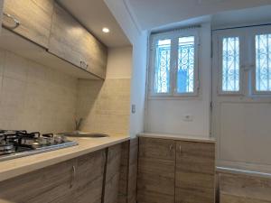 a kitchen with a stove and a sink and a window at Sidi studio 8bis in Sidi Bou Saïd