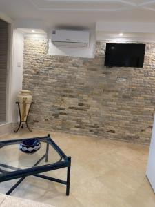 a living room with a stone wall and a tv at Sidi studio 8bis in Sidi Bou Saïd