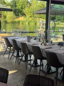 een rij tafels en stoelen met wijnglazen bij Base de loisirs du Colvert in Bonzée-en-Woëvre