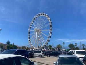 a ferris wheel in a parking lot with cars at Logudoro Cabin by Holiday World in Alghero +4 photos