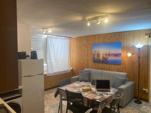 a living room with a couch and a table with a laptop at Logudoro Cabin by Holiday World in Alghero