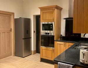 a kitchen with a stainless steel refrigerator and a microwave at Hawks Hideaway in Warminster