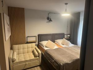 a bedroom with two beds and a chair at Guest Apartments Orłowo in Gdynia