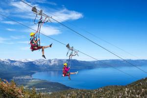 two people on a zip line over a lake at Lakeland Village #476 in South Lake Tahoe