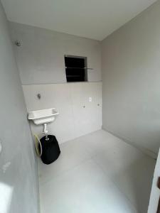 a white bathroom with a sink and a mirror at Casa da Dinda 107 in Rio das Ostras