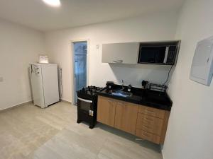 a kitchen with a sink and a refrigerator at Casa da Dinda 107 in Rio das Ostras