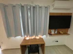 a room with a table and a window with curtains at Casa da Dinda 107 in Rio das Ostras