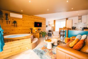 a living room with a tub and a couch at Private spa - La Sparenthèse in Ciney