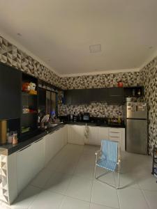 a kitchen with a refrigerator and a chair in it at Good Winds Kite House in Cruz