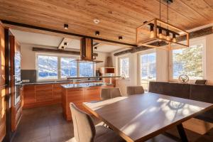 a dining room with a table and some windows at ALPENAPART Ladis - Premium Family Apartments in Ladis