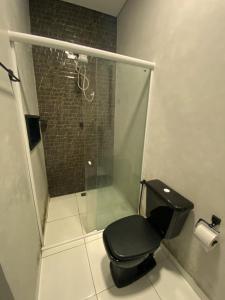 a bathroom with a black toilet and a shower at Good Winds Kite House in Cruz +18 photos
