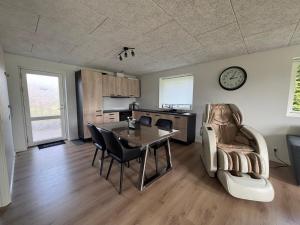 a living room with a table and chairs and a clock at New apartment, only 4 km from the highway in Horsens