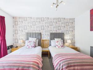 two beds sitting next to each other in a room at Dunroamin Bed and Breakfast in Aviemore