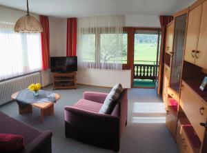 a living room with a couch and a tv at Ferienwohnung Weiß inkl. Chiemgaukarte in Ruhpolding