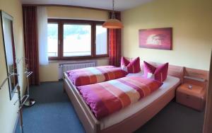a bedroom with two beds with pink pillows at Ferienwohnung Weiß inkl. Chiemgaukarte in Ruhpolding