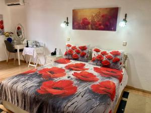 a bedroom with a bed with red flowers on it at Anemones Rooms in Chania
