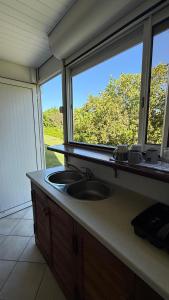 a kitchen counter with a sink and a window at Peace's House, Studio moderne, Bas-du-Fort, Plage à pied, Parking privé in Le Gosier +12 photos