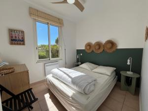 a bedroom with a bed and a window at Adorable maison de vacances plain pied au coeur de la station et proche des plages 4 chambres, jardin, WIFI, LXDUNE1 in Portiragnes